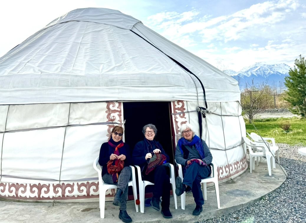 Three women knit outside a felt yurt at southern IssyKul Lake.