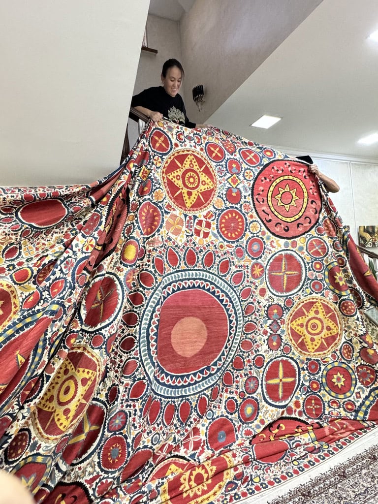 Embroiderer shows of record-size SUZANI that she and students have created.