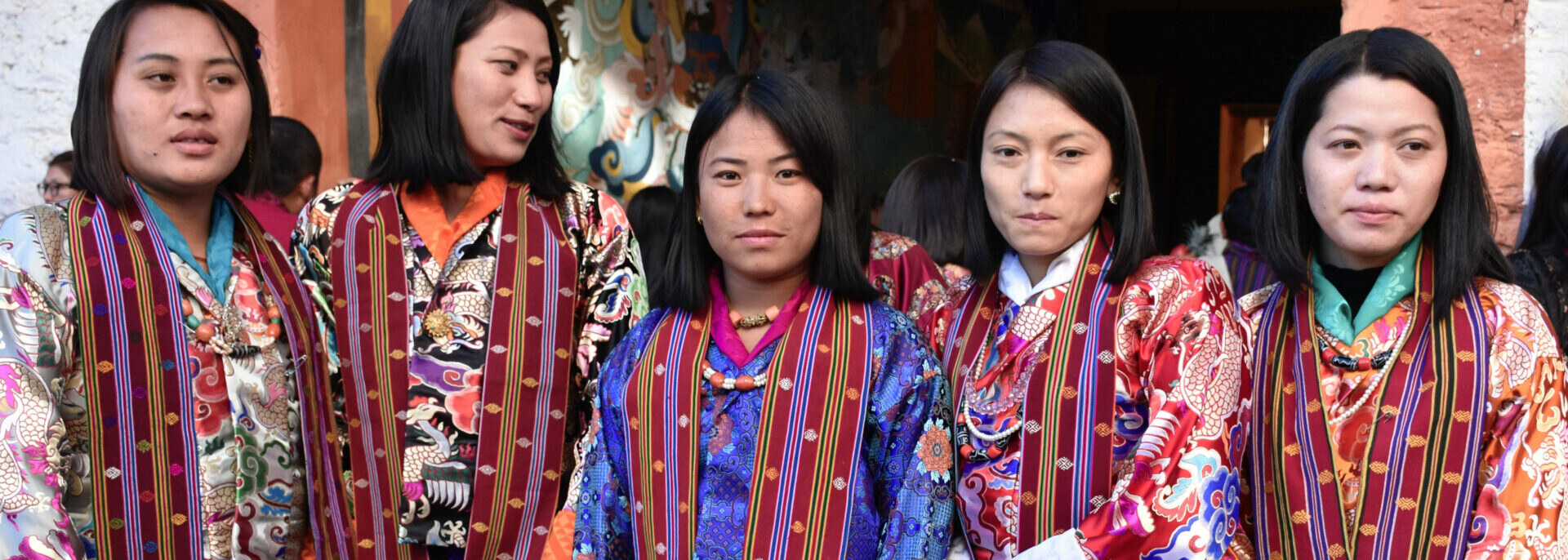 Five young women at a festival pose in their traditional Bhutanese blouses made of imported Chinese brocade.