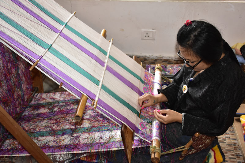 Bhutan weaver working at a slanted loom.