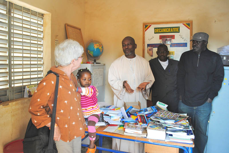 Director in Segou receives BTSA travelers' donations to the school.