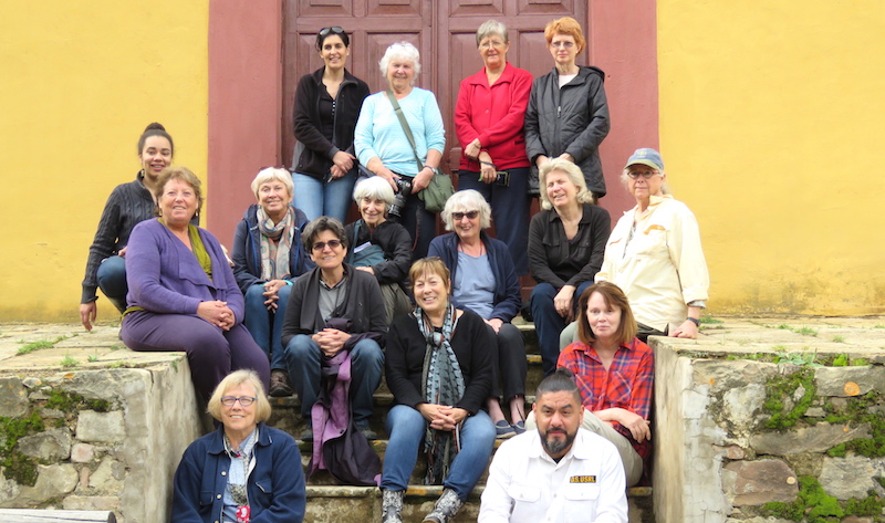 Group sitting on steps of old building in Bolivia.
