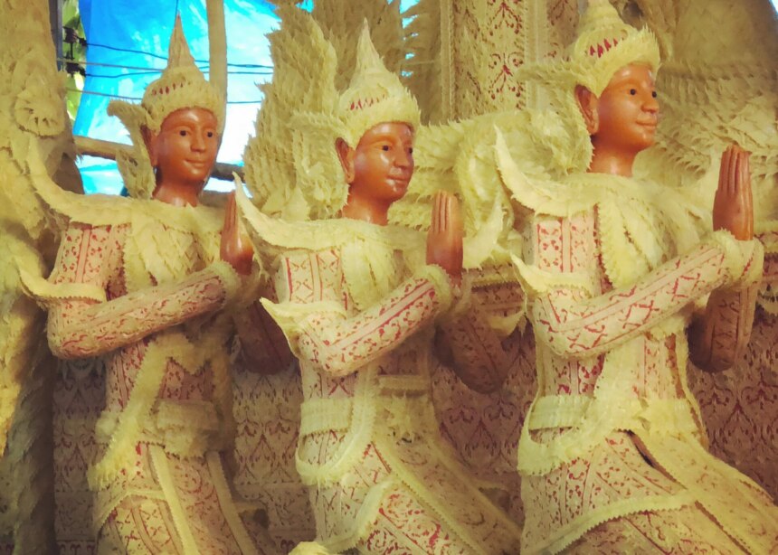 Three life-sized float figures made of delicately carved wax sit in prayer mode on floats for the festival of Khao Phansa, Ubon, Thailand.