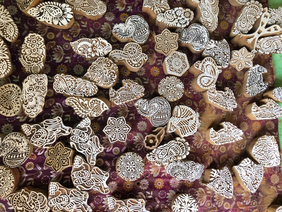 Small wood blocks for stamping cloth, with different designs of flowers, animals, paisleys and mandalas.