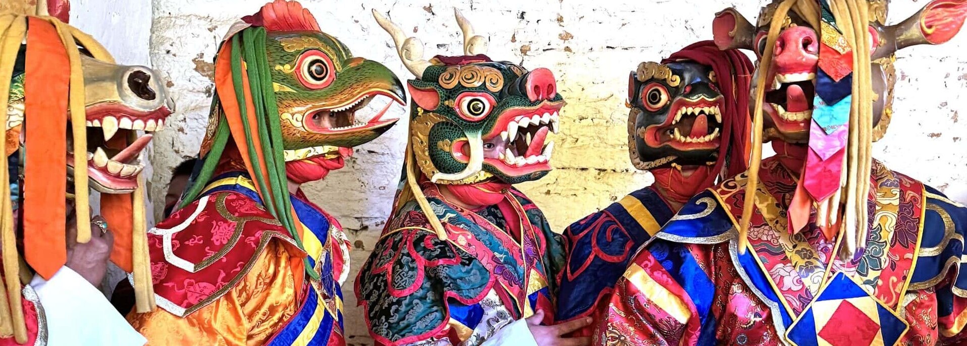 Five dancers with animal masks wait their turn to perform at a tsechu in Bhutan.