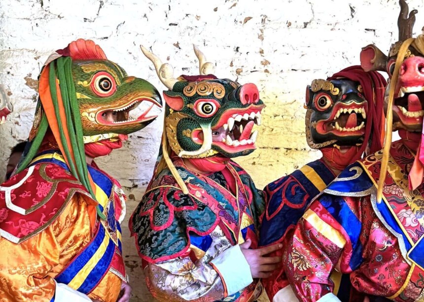 Five dancers with animal masks wait their turn to perform at a tsechu in Bhutan.