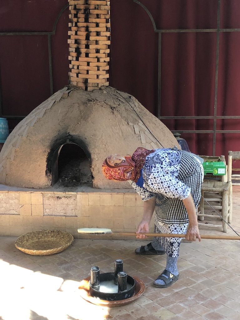Moroccan baker slides another loaf into the wood-fired oven.
