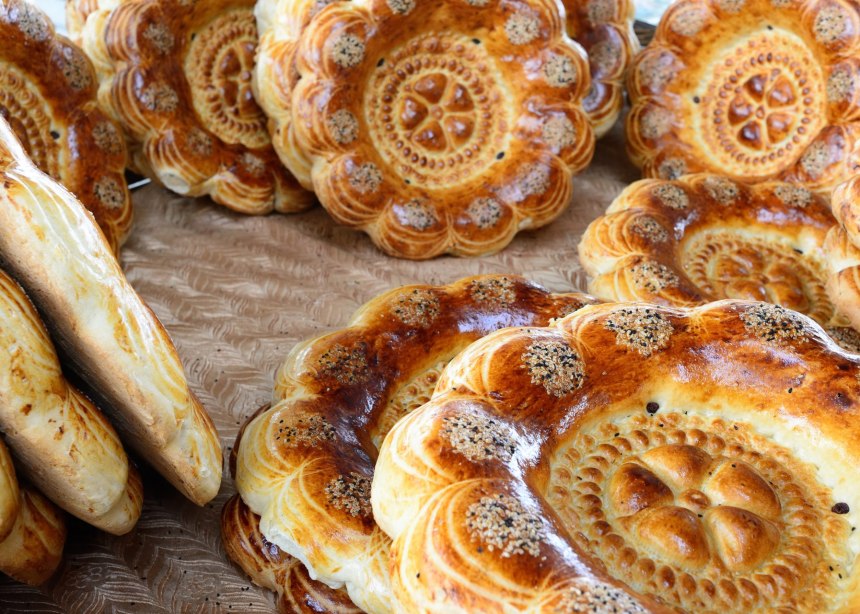 Stacks of round golden breads, decorated with sesame seeds.