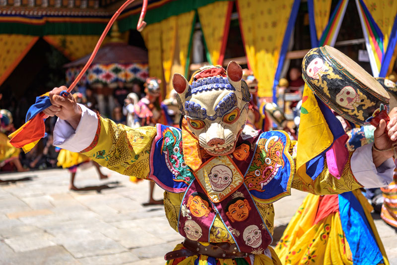 Dancer with wooden mask salutes the crowd.